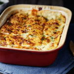 lasagna in dark red baking dish